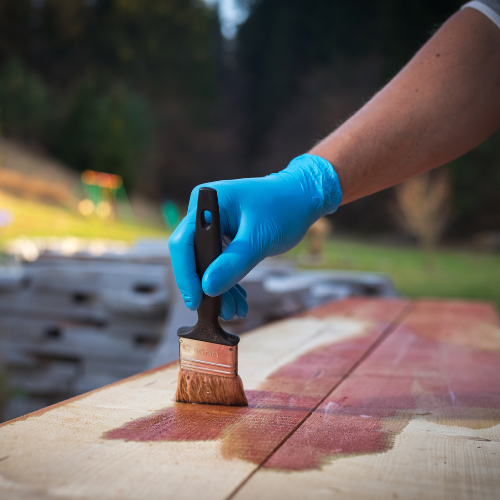 Wood stain being applied to lumber