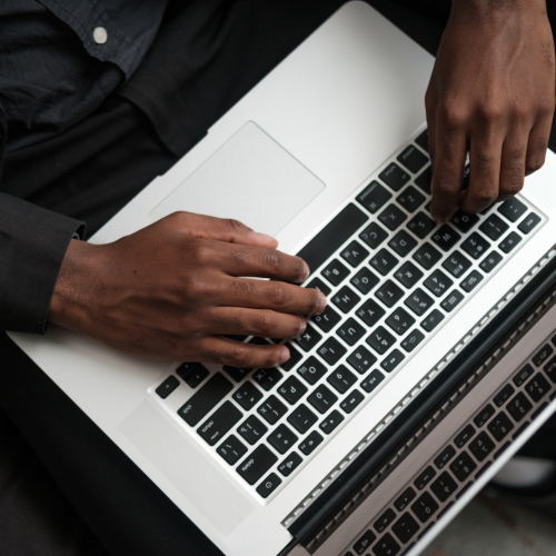 Hands typing on a laptop
